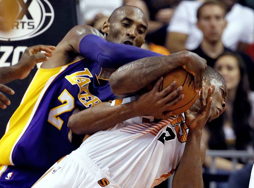 Phoenix, Arizona. Lotta tentacolare in Nba: Kobe Bryant dei Los Angeles Lakers contende la palla ad Eric Bledsoe dei Phoenix Suns (AP)